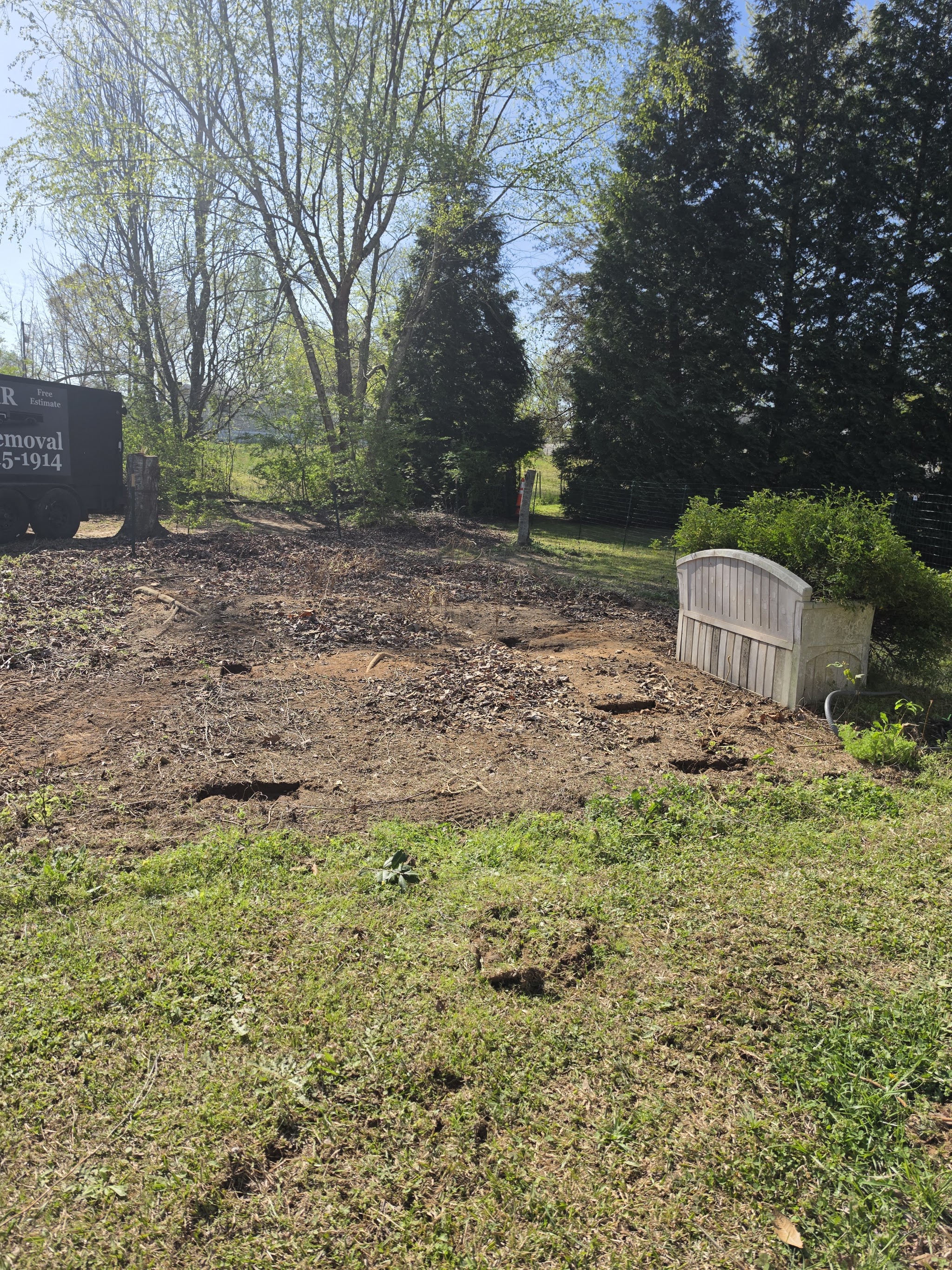 A yard cleared of debris, bare ground ready for grass