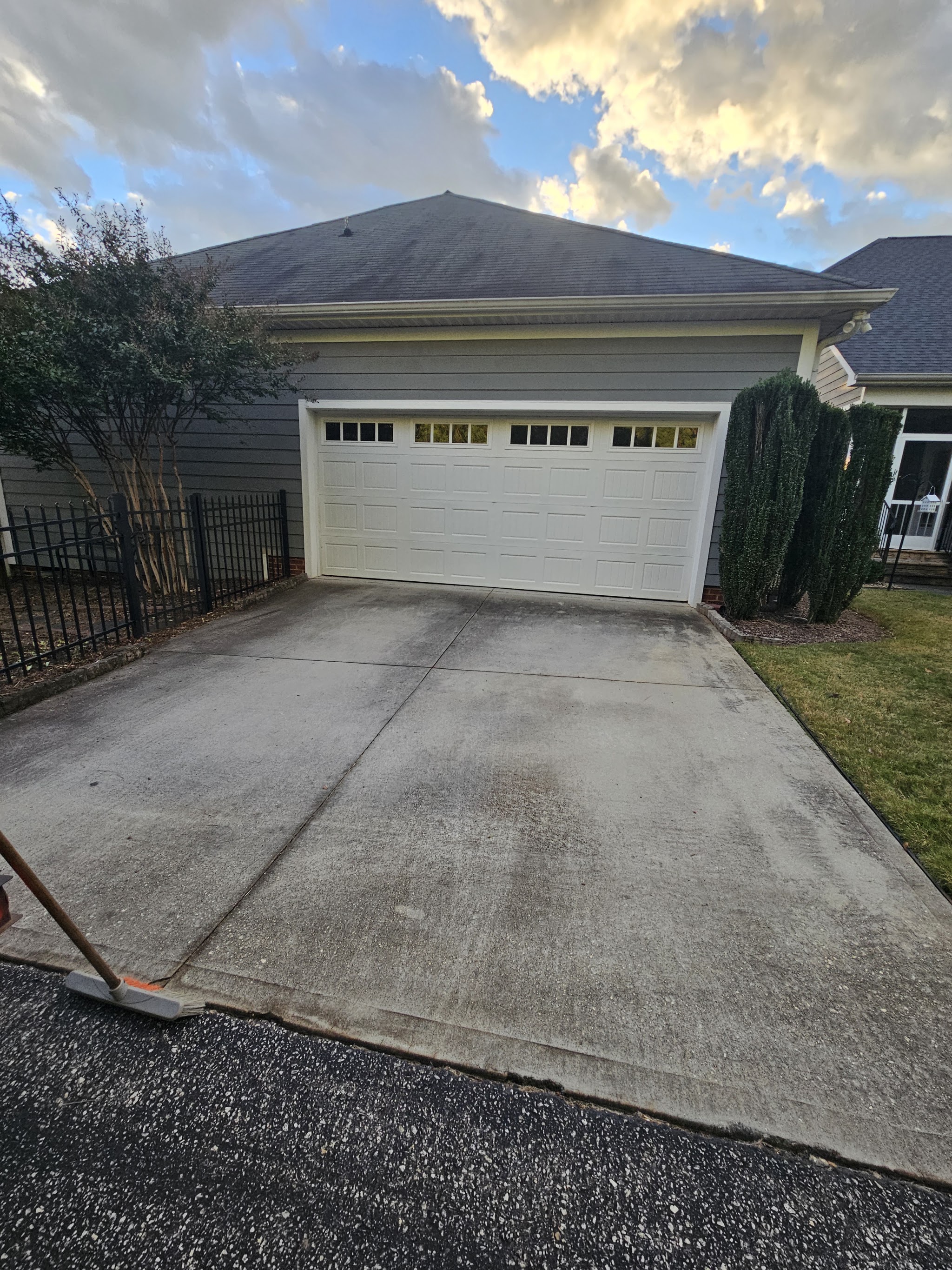 A swept driveway and garage door after a cleanup