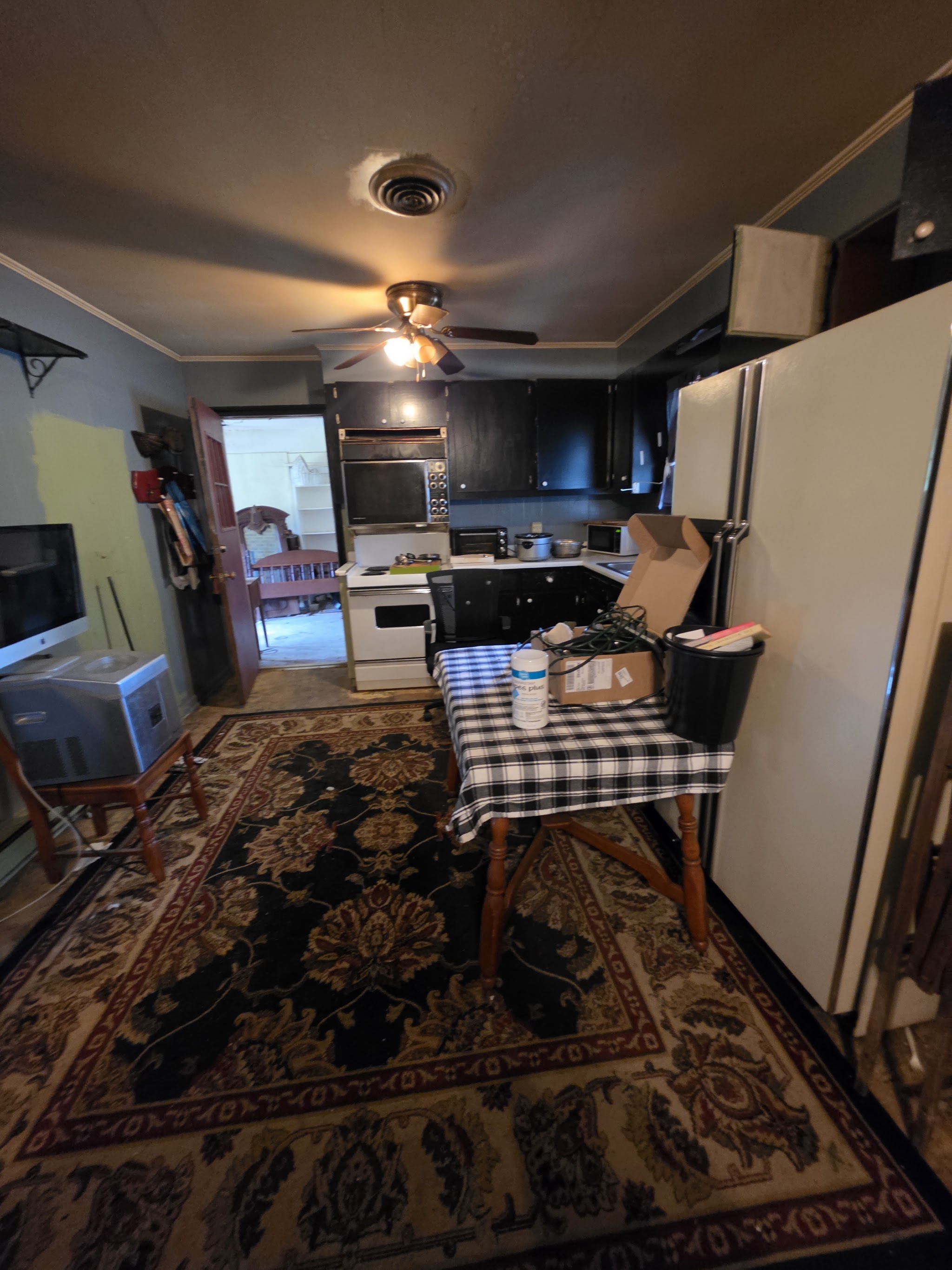 A kitchen and dining room full of furniture and belongings